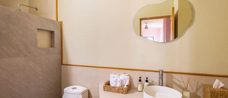 Un baño moderno con inodoro, bidé y un espejo grande.