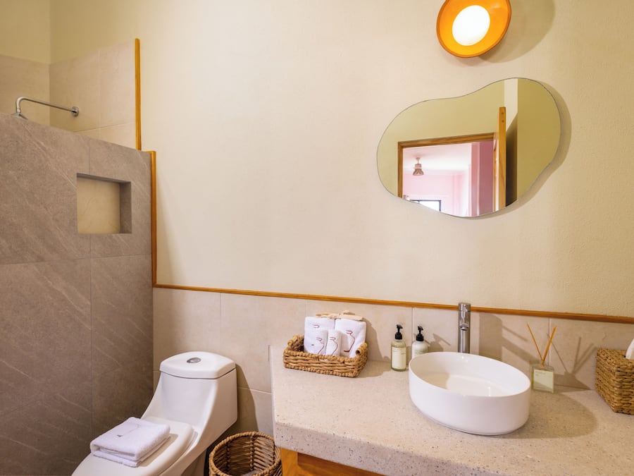 A modern bathroom with a toilet, bidet, and a large mirror.
