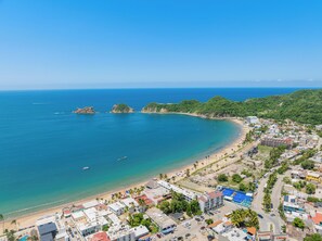 Un pueblo costero con playa, edificios y cielo azul despejado.