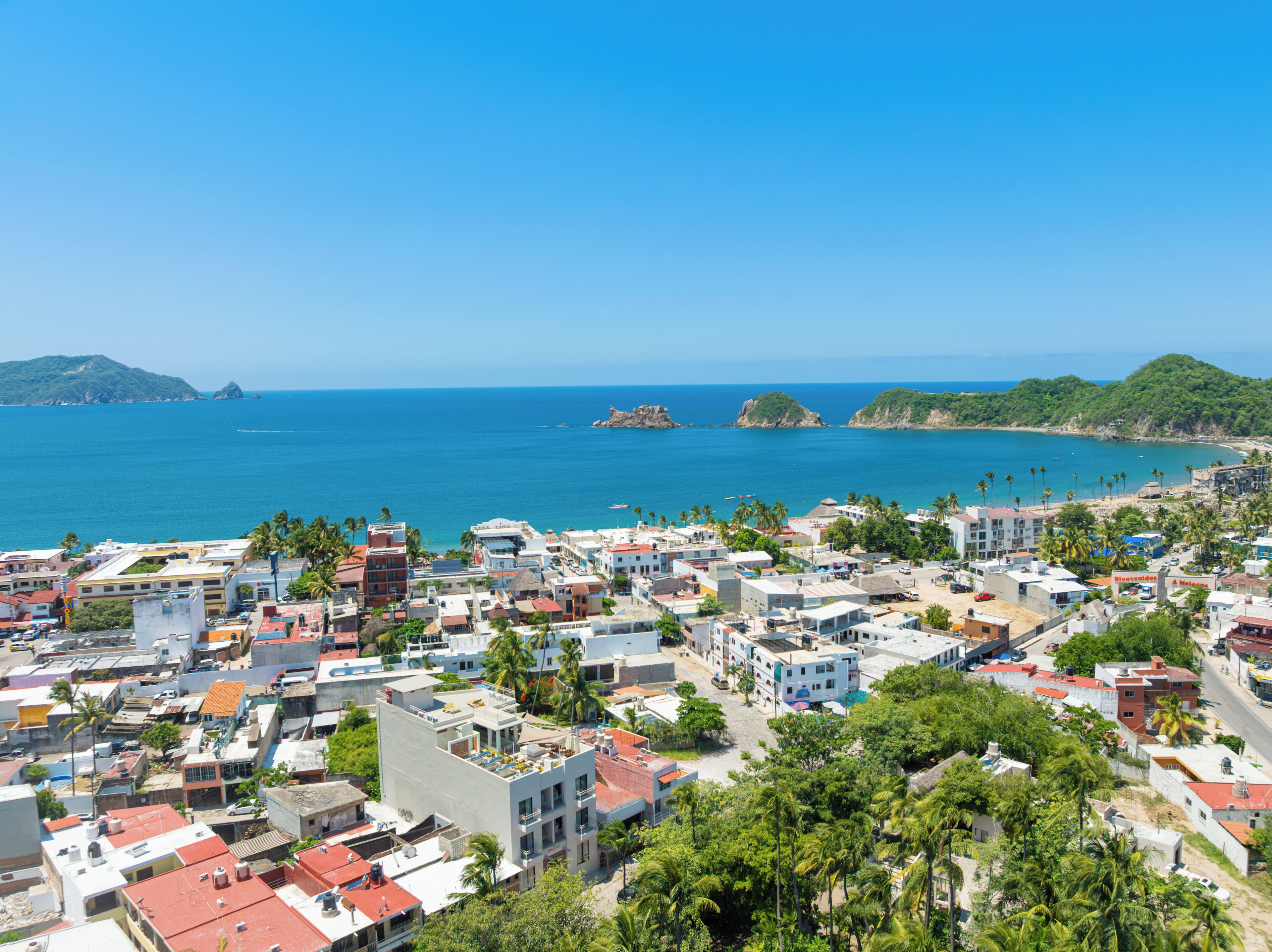 Un pueblo costero con edificios, una playa y un cielo despejado.