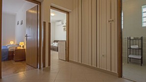 Un couloir comprenant un lit, des lampes de chevet et une salle de bain avec un porte-serviettes.
