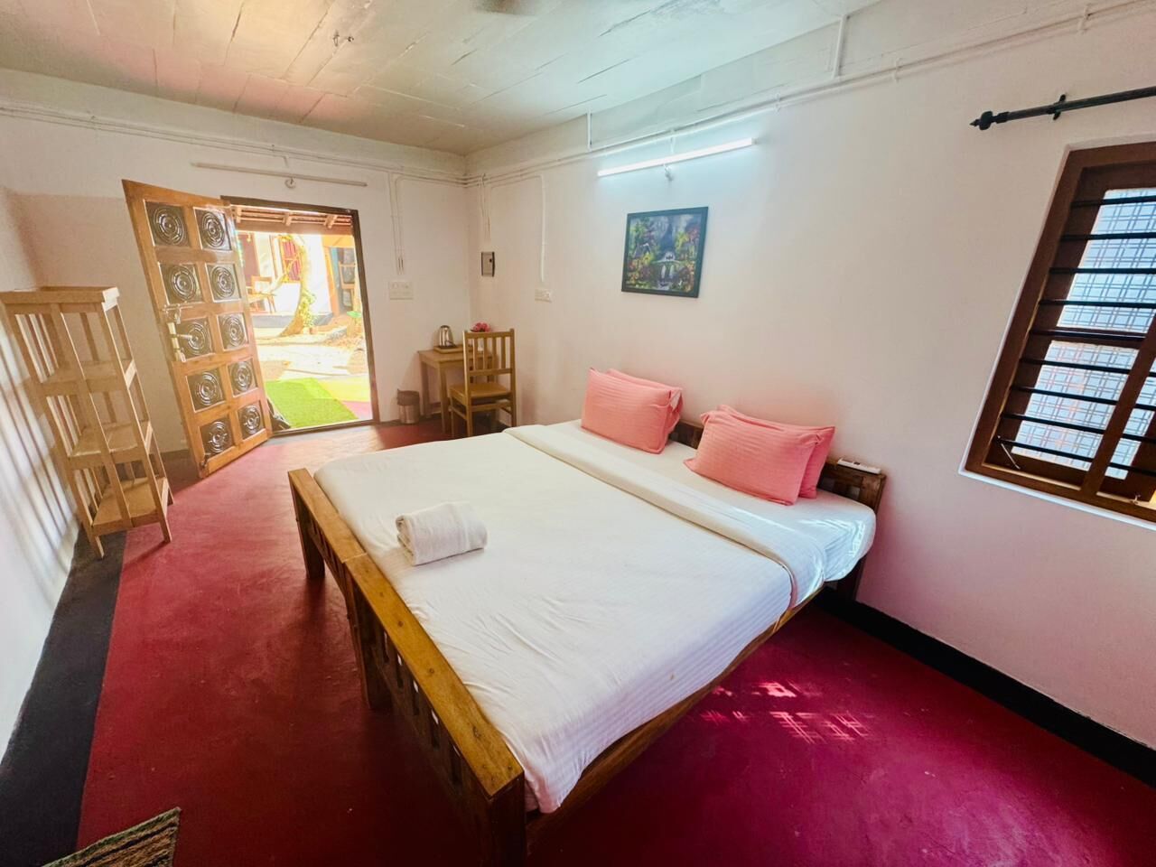 Una habitación con cama, ventana y puerta que da al exterior.