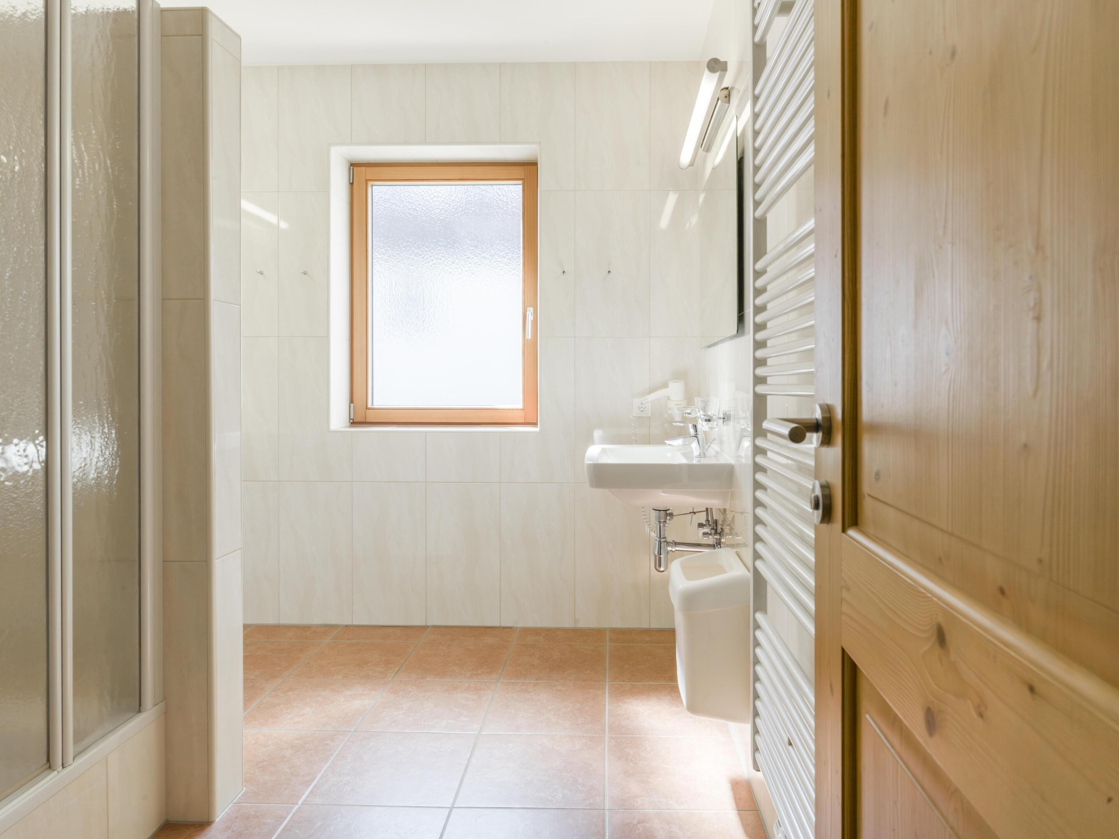 A bathroom with a window, a sink, and a toilet.