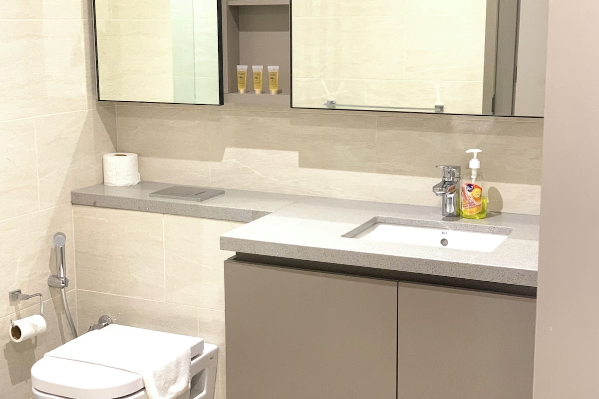 A bathroom with a sink, mirror, and toiletries.