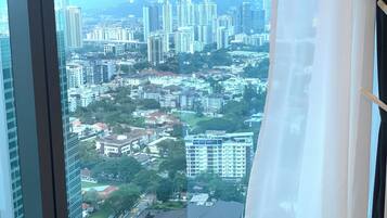 A cityscape through a window with a curtain.