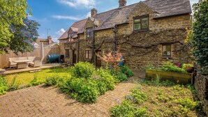 A stone house with a garden and a paved area. - Tom Callows Gorgeous Cottage Oxfordshire (Banbury)