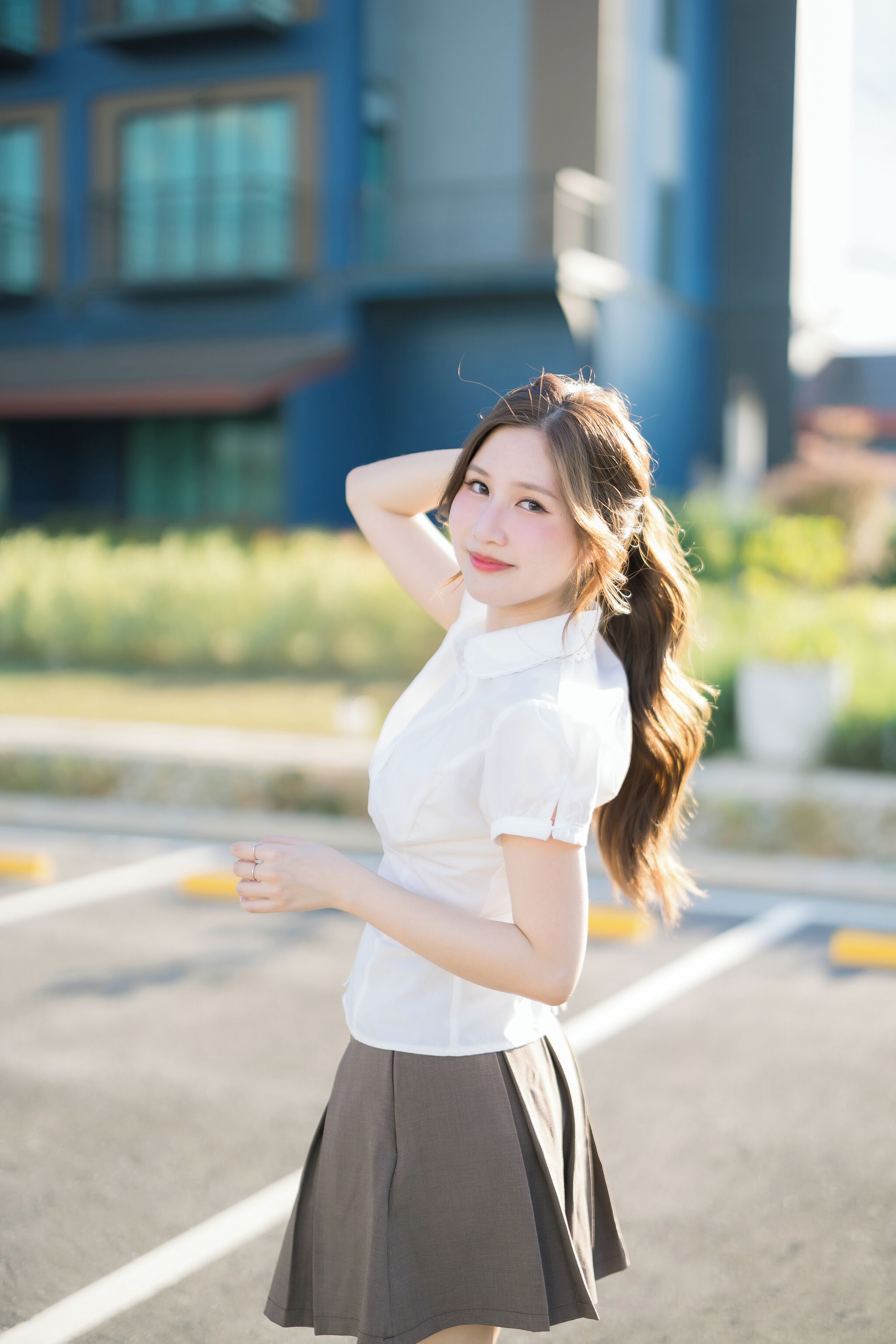 A person standing outdoors with buildings in the background.