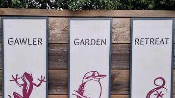 Three vertical signs with names and animal illustrations: 'GAWLER', 'GARDEN', and 'RETREAT'.