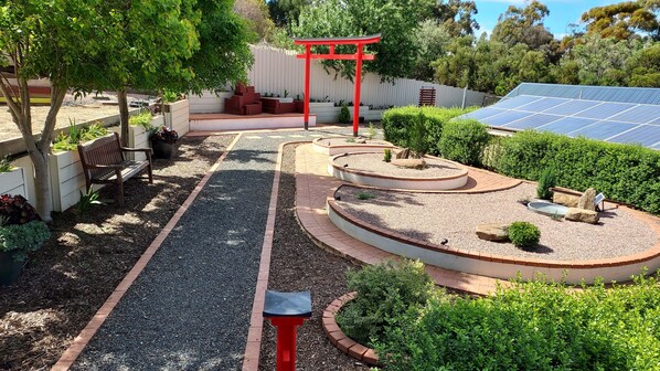 A garden with a red torii gate, a bench, and a solar panel array. - Gawler Garden Retreat
2-br unit in Evanston, Gawler SA 20min to Barossa Valley. (Evanston)