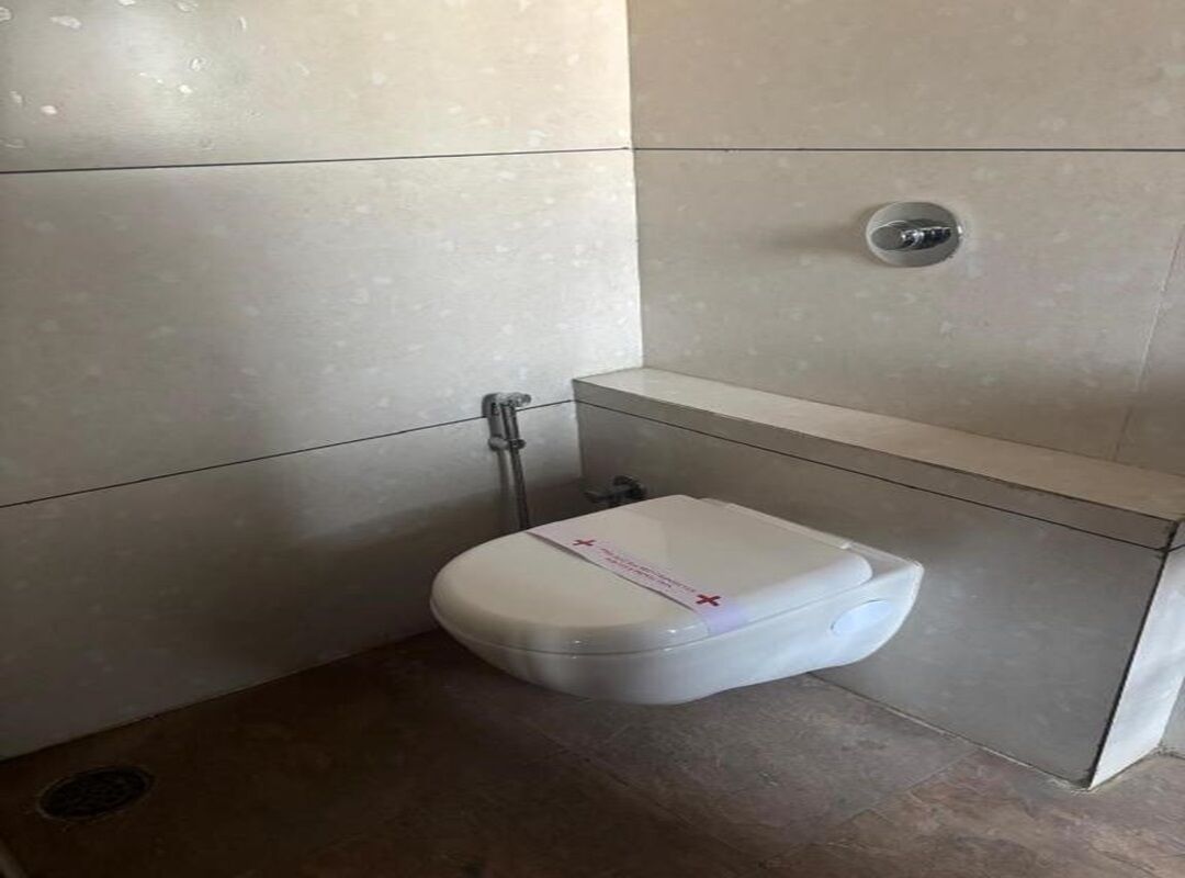 Un baño pequeño y moderno con inodoro blanco, ducha y lavamanos.