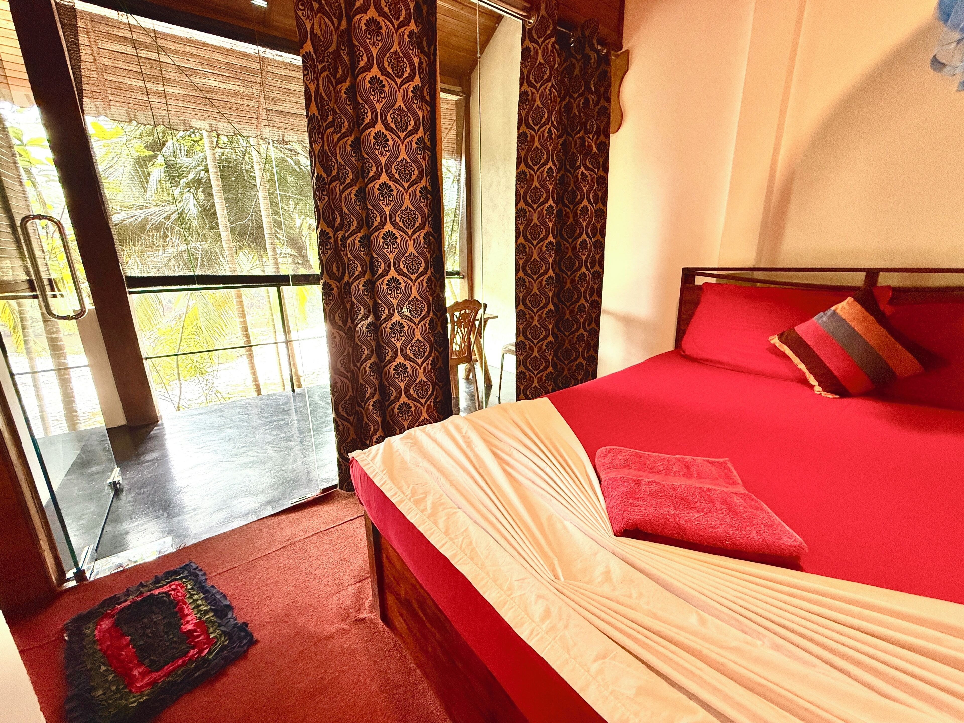 Une chambre avec un lit, une fenêtre avec des rideaux et une vue sur la verdure.