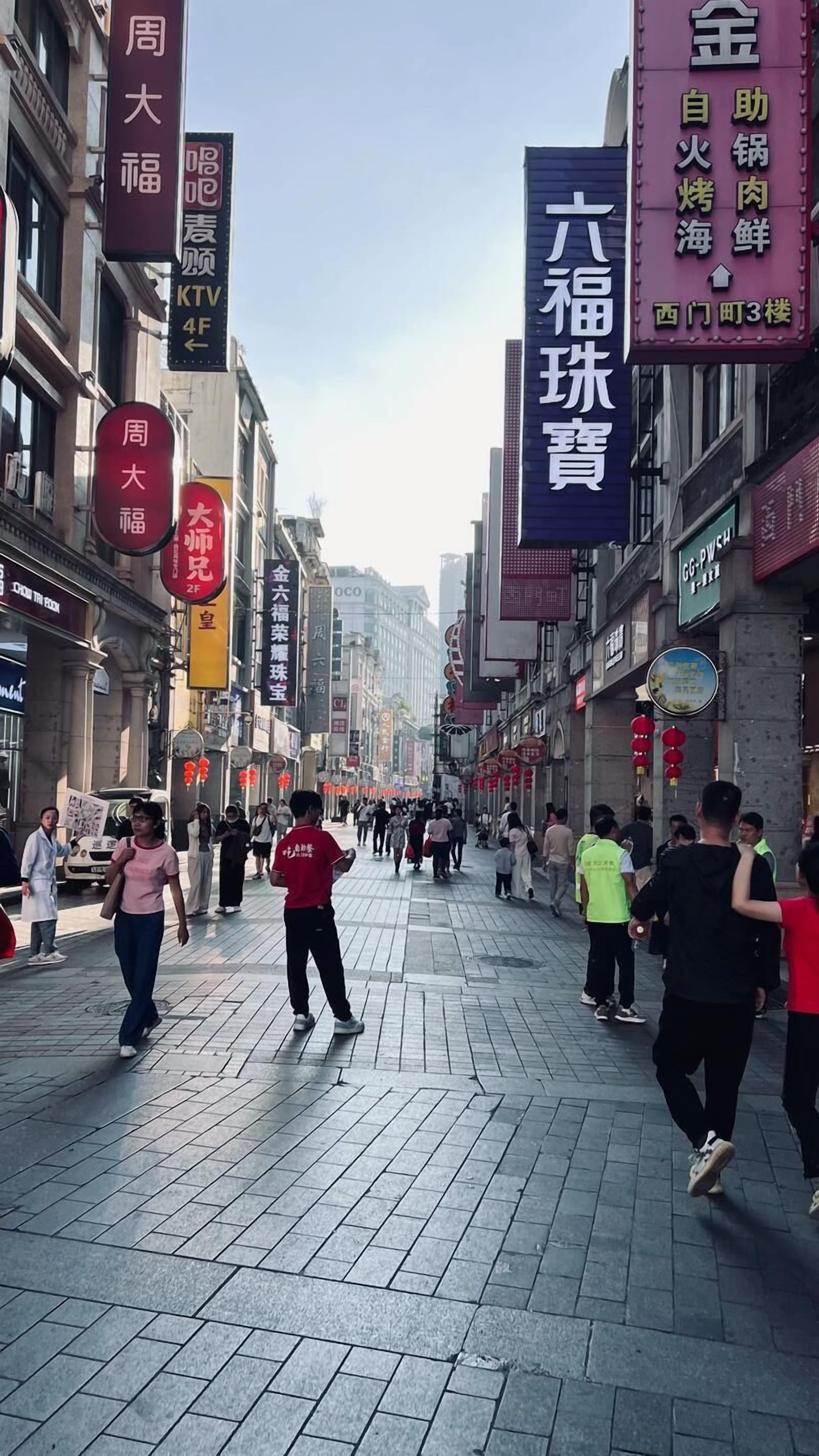 A busy street with various shops and signs in a foreign language.