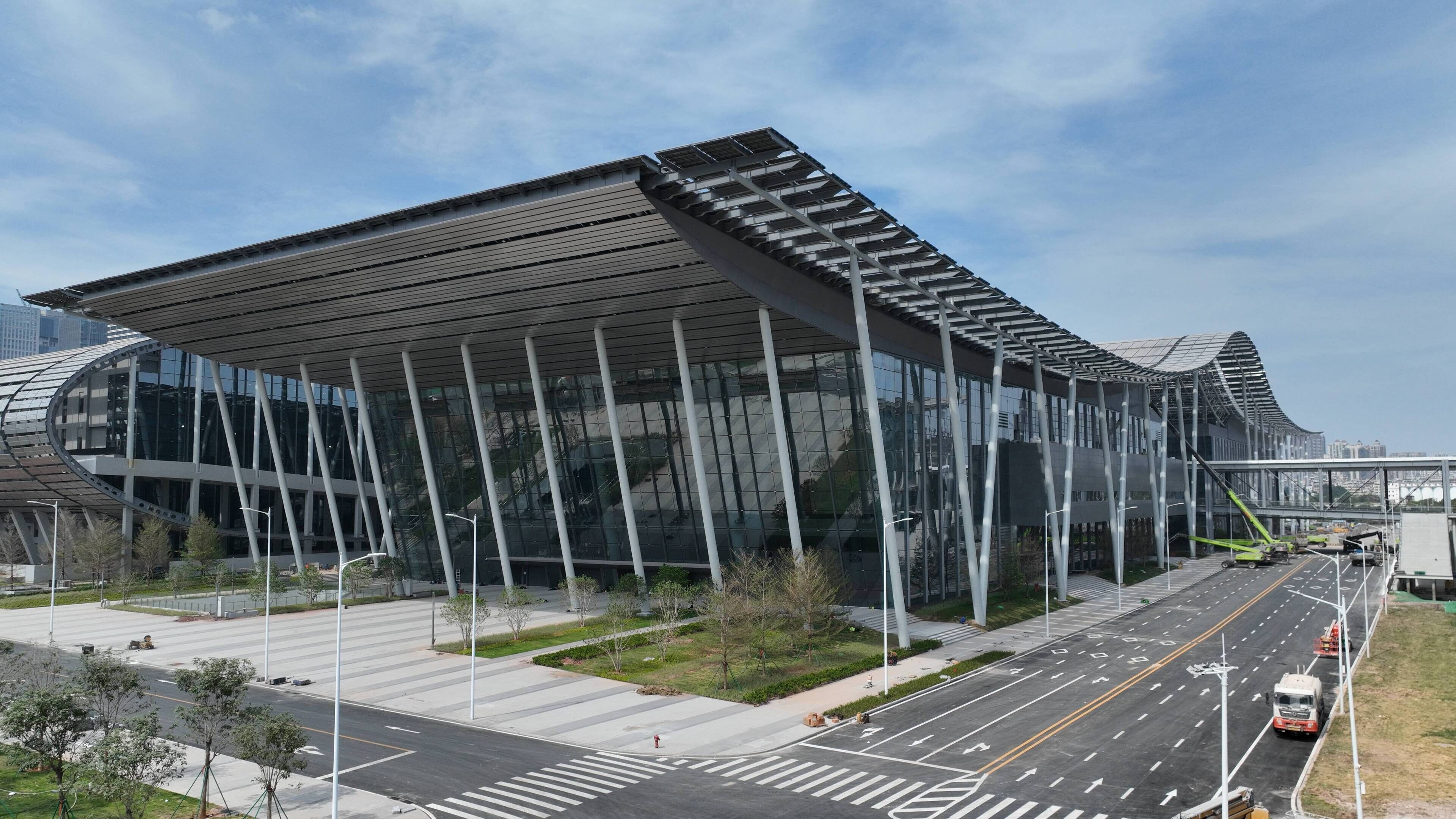 A modern building with a glass facade and a unique roof structure.