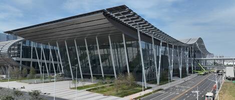 Un bâtiment moderne doté d’une façade en verre et d’une structure de toit originale.