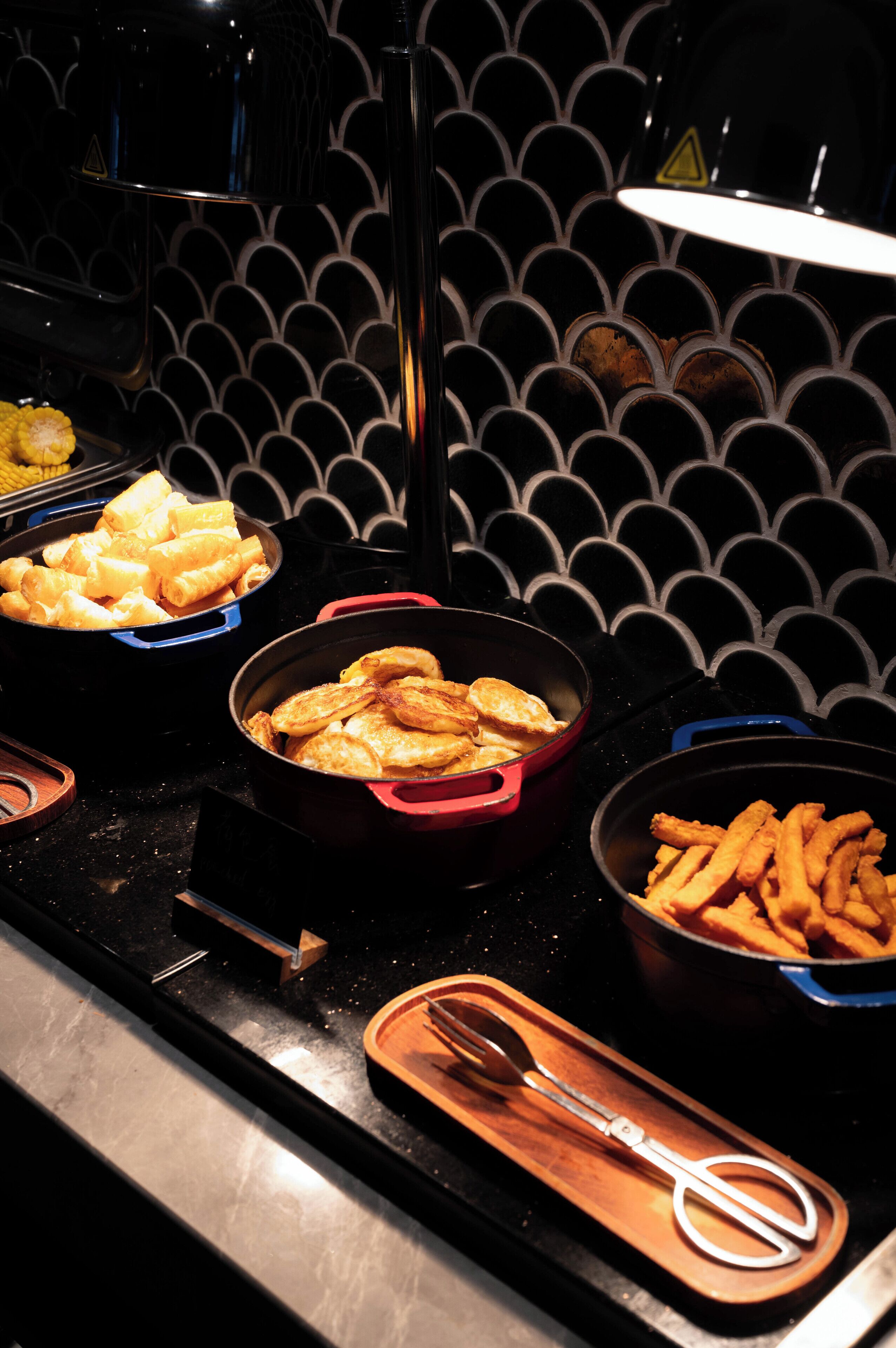 A buffet with various food items including pasta, fried chicken, and fries.