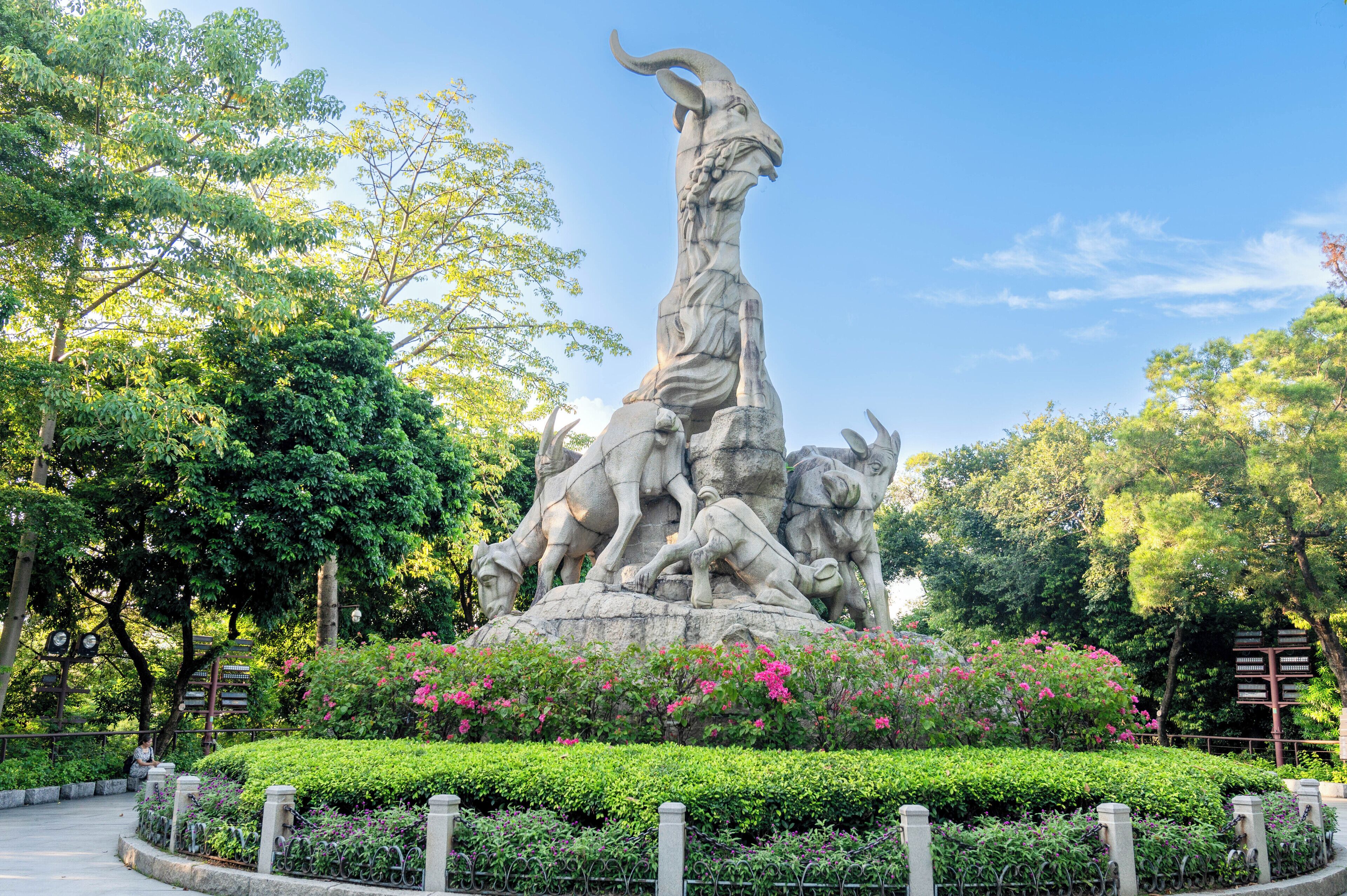 Monumento de piedra con figuras en un parque.