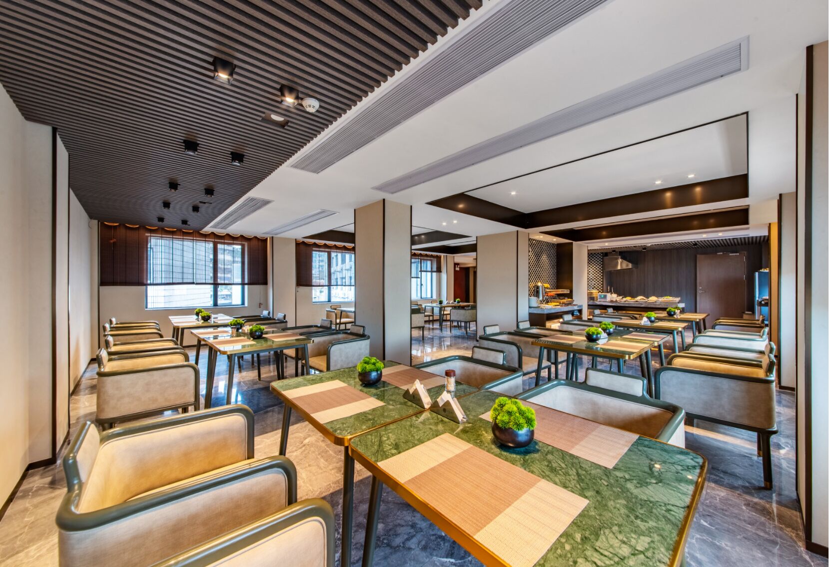 A modern hotel lobby with multiple seating areas, large windows, and a central reception desk.