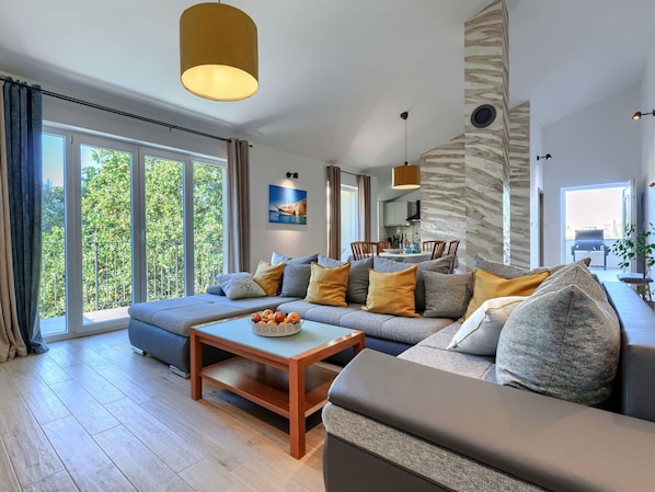 A modern living room with a sofa, coffee table, and dining area.
