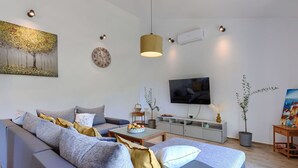 Una sala moderna con sofá, televisor y obras de arte.