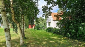 Une pelouse bien entretenue, avec une maison en arrière-plan.