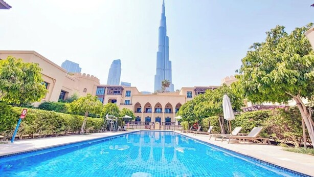 A swimming pool with a view of the Burj Khalifa in the background.