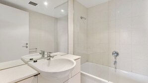Un baño moderno con lavamanos doble, bañera y cabina de ducha de vidrio.