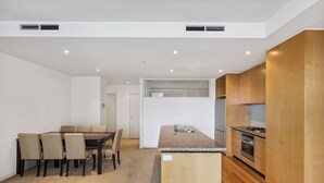 Una cocina moderna con una isla central, armarios de madera y electrodomésticos integrados.