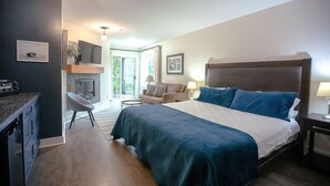Une chambre à coucher avec un grand lit, un bureau, une chaise, un canapé et une cheminée.