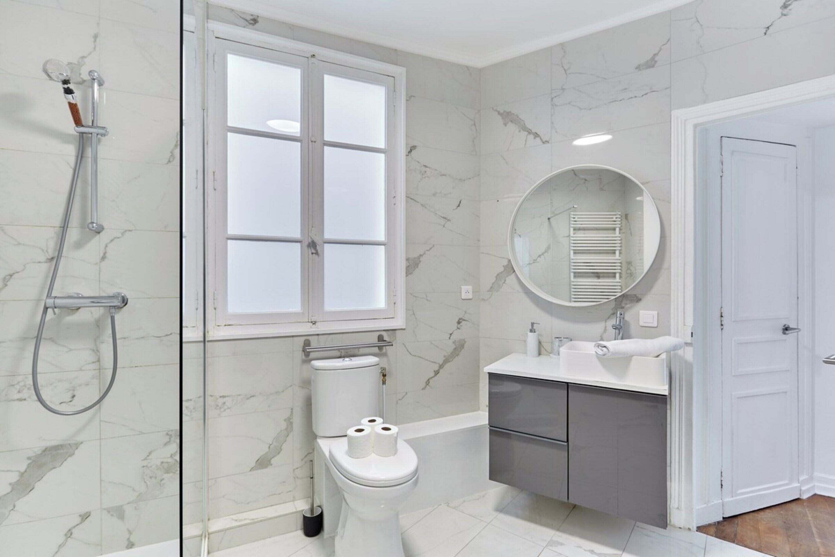 A bathroom with a toilet, bidet, and shower.