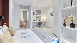 A hotel room with a bed, a desk, a chair, and a bookshelf. - Sublime 3 Bedroom Flat Palais Royal Bourse (Paris)