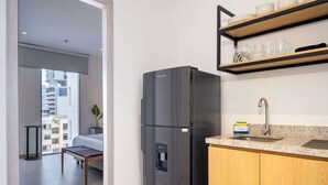 A modern kitchen with a black refrigerator, a granite countertop, and a wooden cabinet.