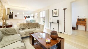 A spacious living room with a sofa, coffee table, and a wooden cabinet. - Superb Terrace Apart Champs Elysees Eiffel Tower (Paris)
