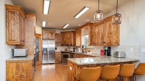 Una cocina con gabinetes de madera, electrodomésticos de acero inoxidable y encimera de granito.