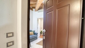 A brown door with a silver handle, a light switch, and a keyhole.
