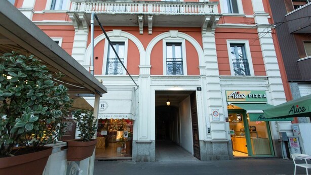 A building with a shop on the ground floor named 'Alice Pizza'.