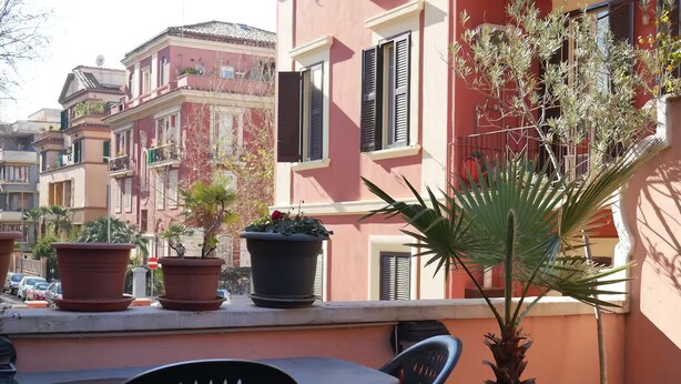 A balcony with potted plants, a table, and chairs. - Lovely apartment by the sea in Rome (Ostia Lido) (Lido di Ostia)