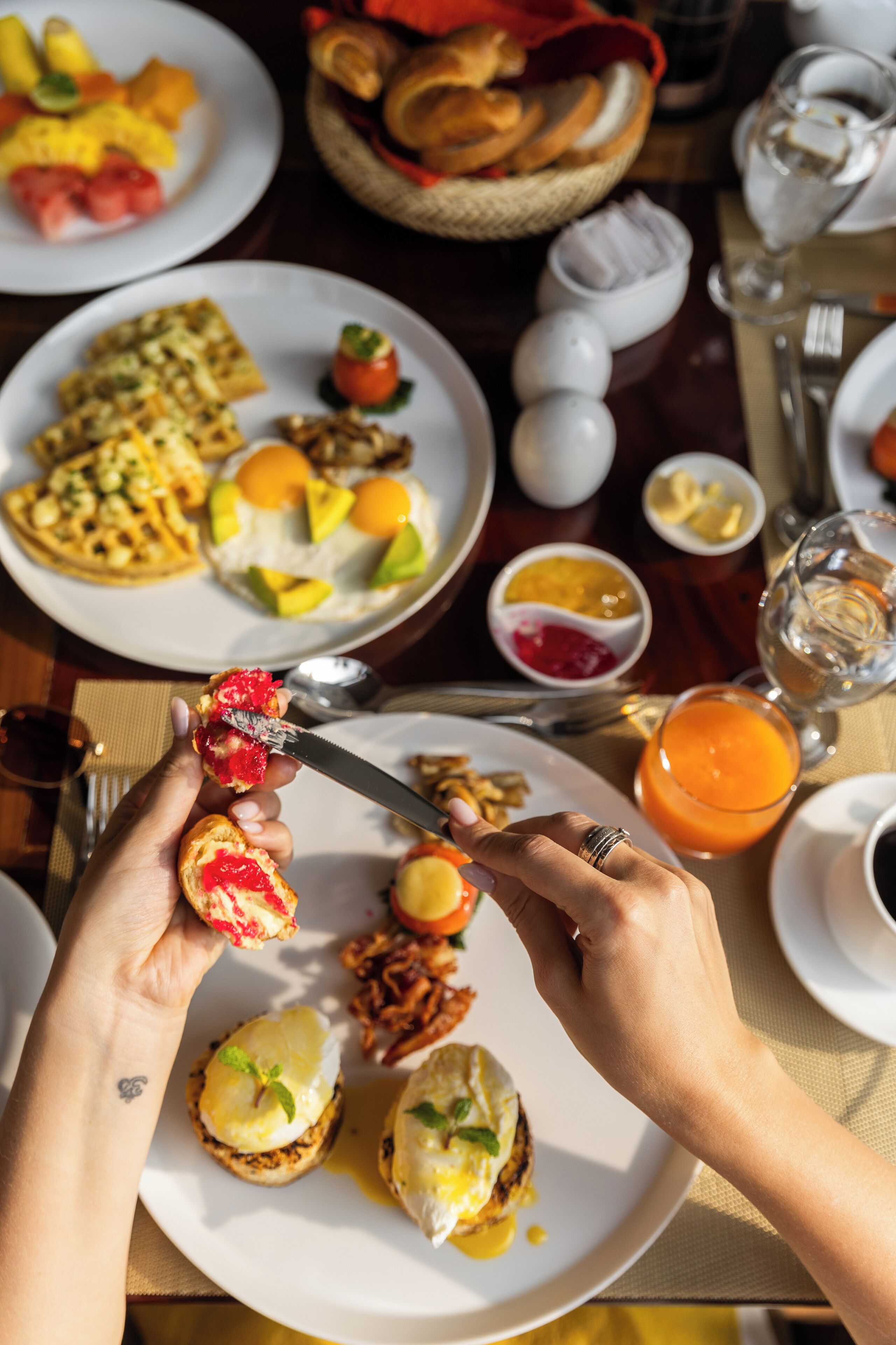 A breakfast setting with various dishes, including eggs, toast, and fruit.