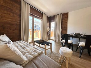 Une pièce confortable avec un canapé, une petite table et un coin repas avec des chaises.