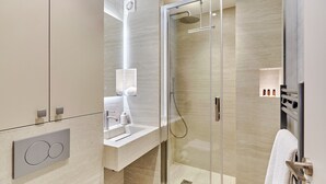 A modern bathroom with a glass-enclosed shower, a vanity with a mirror, and a towel rack. - Sublime and new Studio Center of Paris (Paris)