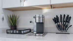 Eine Küche mit Kaffeemaschine, einem Schneidebrett und einem Blumentopf.