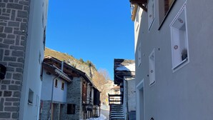 Eine enge Kopfsteinpflasterstraße, begrenzt von Häusern mit Stein- und Stuckfassaden, die zu einer Treppe führt.