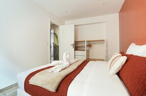 Una camera d'albergo con un letto, un armadio e un ingresso che dà su un bagno.