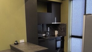A modern kitchen with dark countertops, a built-in oven, and a coffee maker.