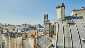 A densely packed urban area with closely built rooftops and a variety of architectural styles, including some with visible chimneys and dormer windows. - Sublim Studio Beaubourg/le Marais (Paris)