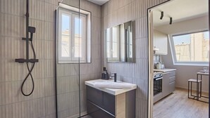 A modern bathroom with a glass shower enclosure, a vanity with a sink, and a large mirror. - Sublim Studio Beaubourg/le Marais (Paris)