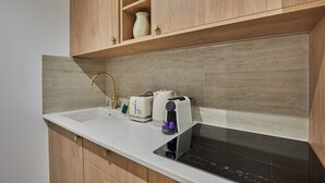 A kitchen with a white countertop, a built-in stove, a sink, and wooden cabinets. - Superb Apartment in the Heart of Paris (Paris)