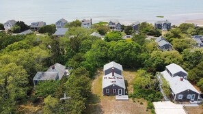 A residential area with houses surrounded by trees, including a house labeled "27 Beach Plum Lane".