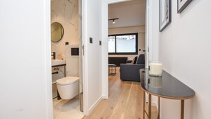 A modern apartment with a bathroom, a living area with a sofa and a table, and a large window. - Welcoming Apartment - 1br/4p - Arc de Triomphe (Paris)