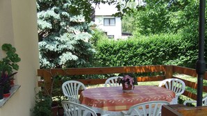 A patio with a table and chairs, surrounded by potted plants and a wooden fence. - Well-kept apartment in Fonyod for 4-5 people within walking distance of the lake - new air conditioning (Fonyód)