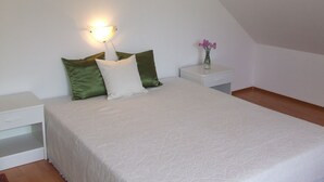 A bedroom with a bed, a nightstand, a lamp, and a vase with flowers. - Well-kept apartment in Fonyod for 4-5 people within walking distance of the lake - new air conditioning (Fonyód)